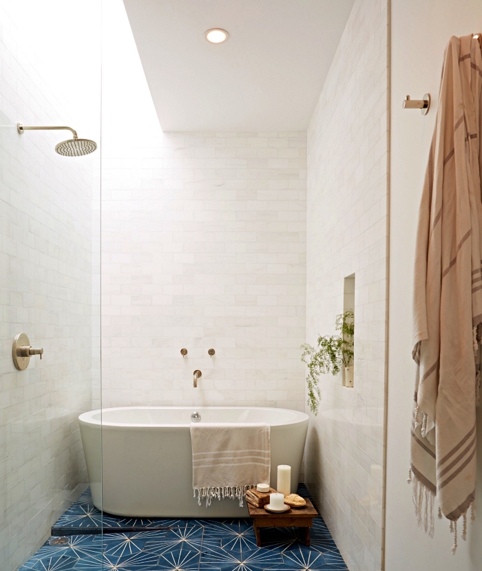 une salle de bain blanche avec douche et baignoire qui semblent se fondre dans le décor