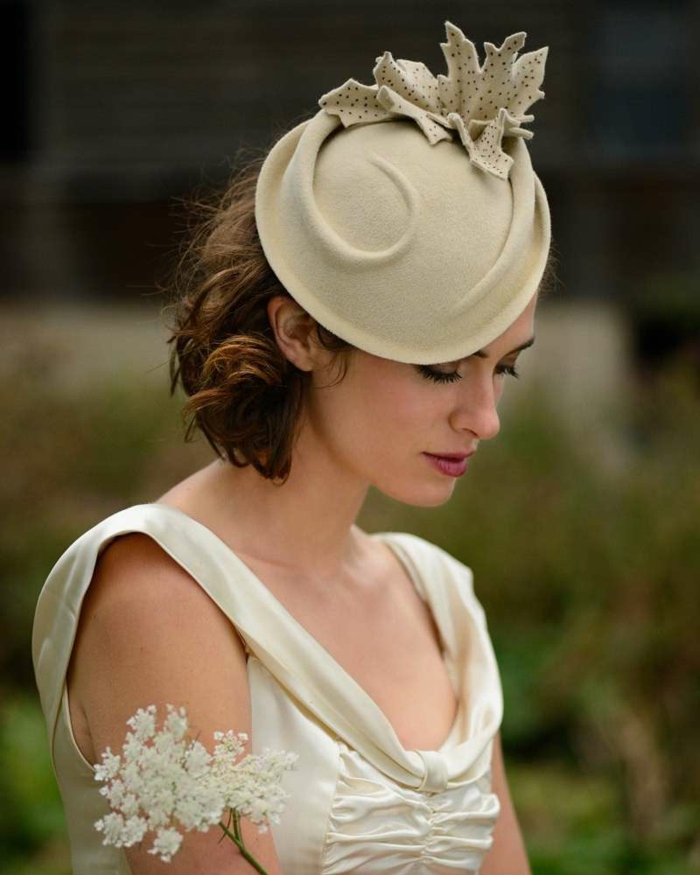 chapeau beige, feuille en tissu décorant le chapeau, carré cheveux bouclés , robe crème