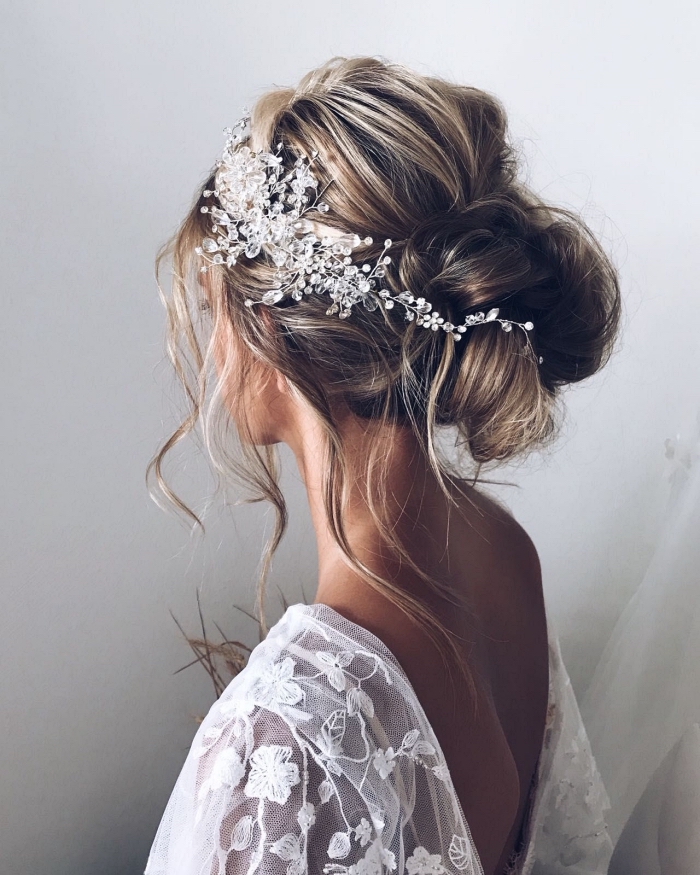 chignon mariée bohème chic accessoirisé avec bijou de cheveux en strass, coiffure de mariée avec chignon bas volumineux