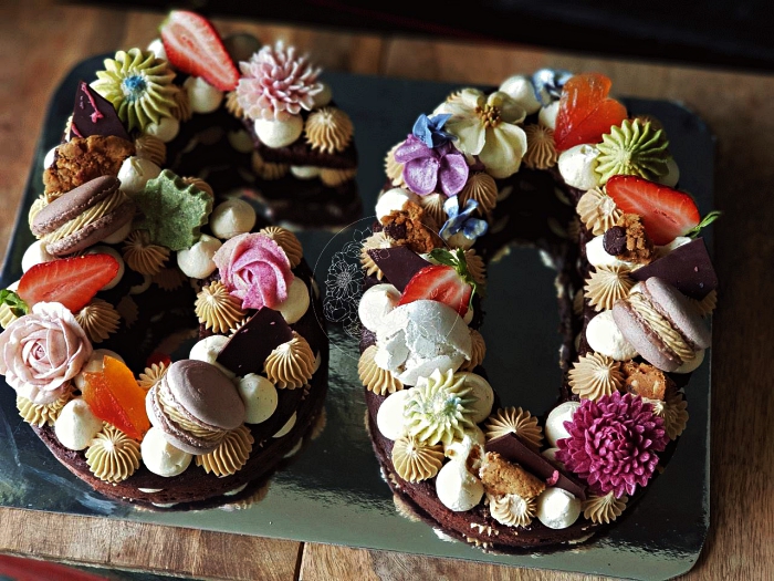 number cake chocolat au décor de meringues, macarons, rosaces en glaçage coloré et morceaux de chocolat