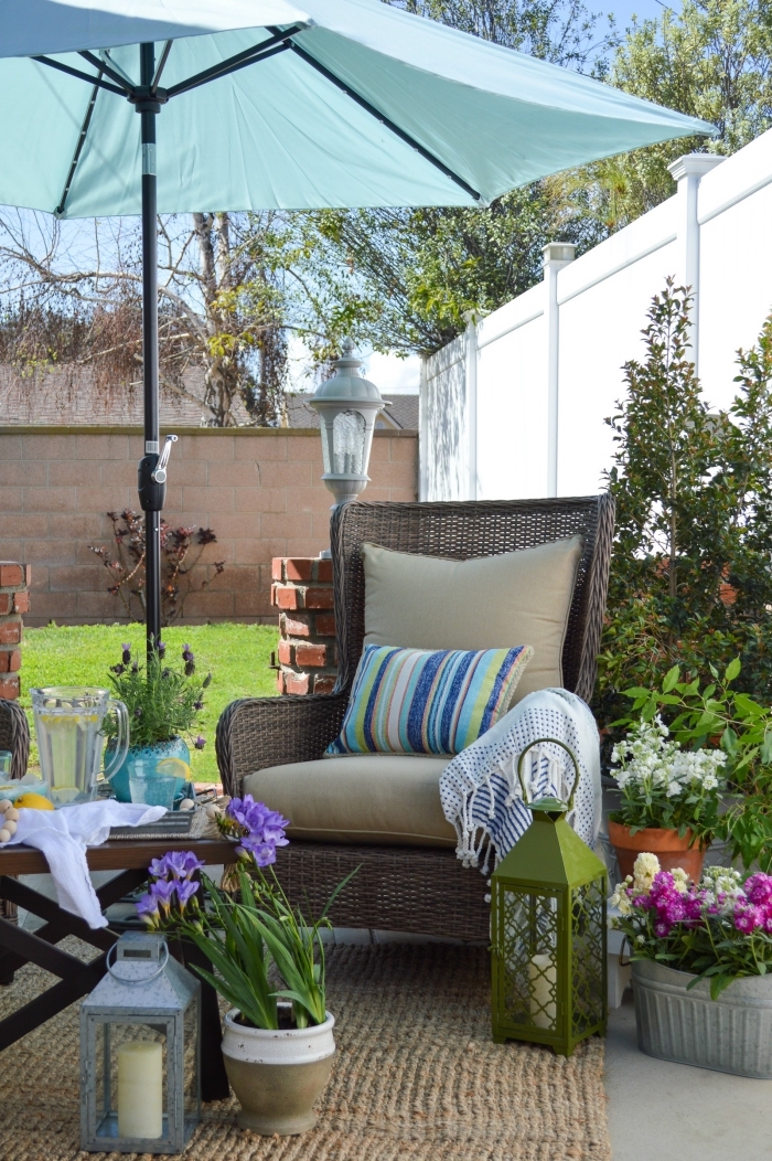 aménagement extérieur maison avec meubles tressés, modèle de tapis beige extérieur, pots à fleurs et bacs colorés