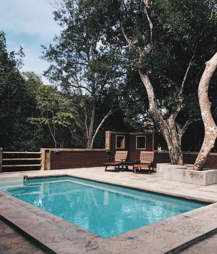espace baignade minimaliste avec petite piscine en coque polyester de forme rectangulaire et sa plage de piscine en béton