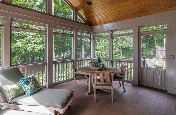 veranda moderne fermée, table ronde en bois, chaise longue, toiture en bois, fenêtres de véranda blanches