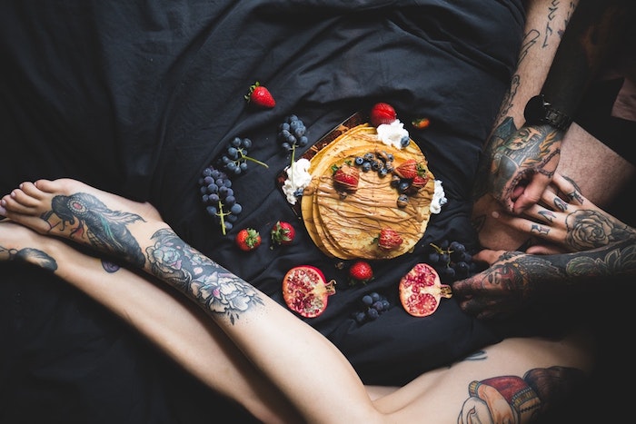 Couple tatoué, crêpes et fruits, petit déjeuner au lit, motif tatouage, dessin tatouage original, encre dessin sur la peau