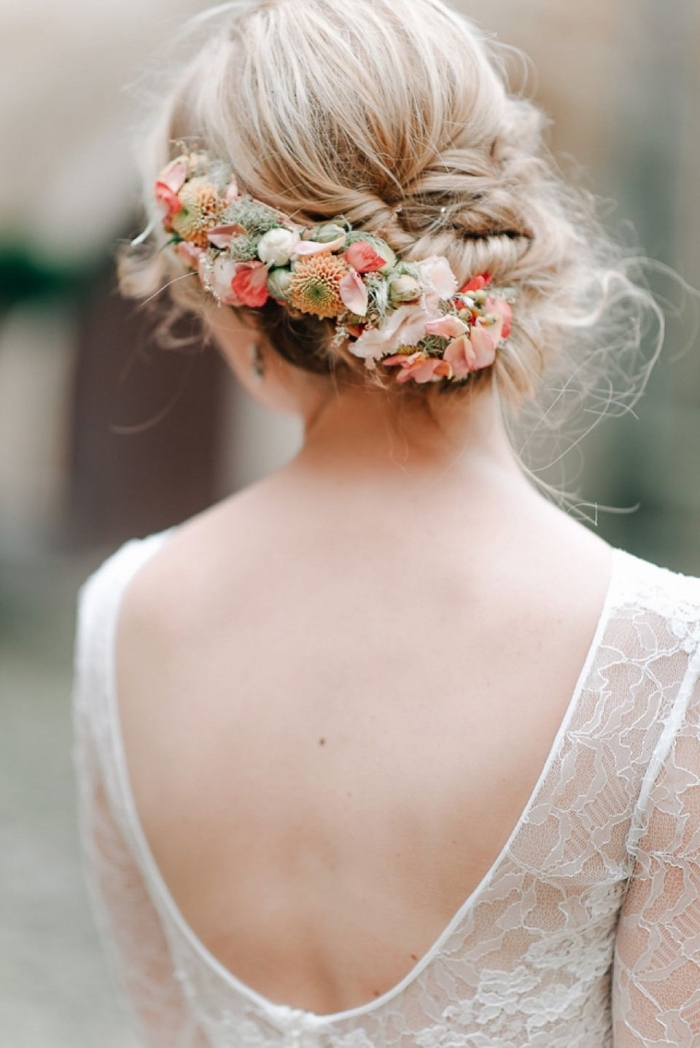 look de mariée avec coiffure mariage chignon torsadé bas accessoirisé de fleurs, coiffure avec chignon bohème