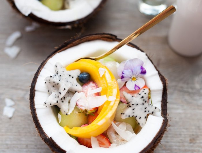 salade fruits tropicale avec des fraises melon bleuets mango et autres fruits servis dans un noix de cooco