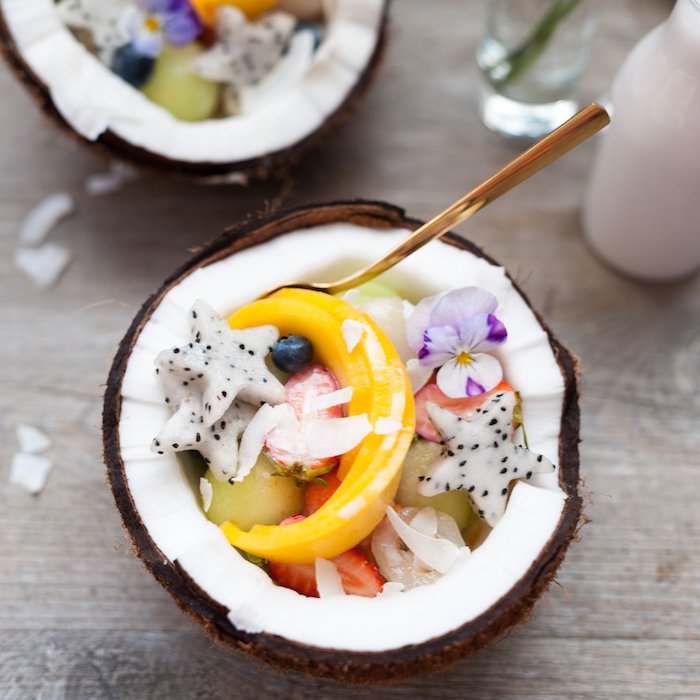 dessert facile et léger, noix de coco rempli de fruits tropicaux coupés en formes variées