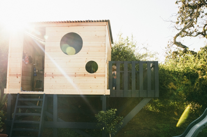 idée comment construire une cabane avec terrasse peinte en noir mate, modèle de maison bois avec fenêtre ronde