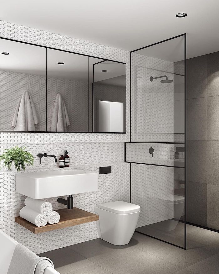 Noir métal détails dans une salle de bain grise avec carrelage blanche, salle de bain blanche et bois décoré bien 
