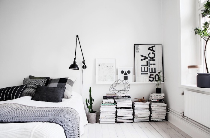 Chambre style scandinave a noir et blanc, livres rangement sur le sol en bois, lit avec rangement, astuce rangement chambre, belle chambre à coucher 