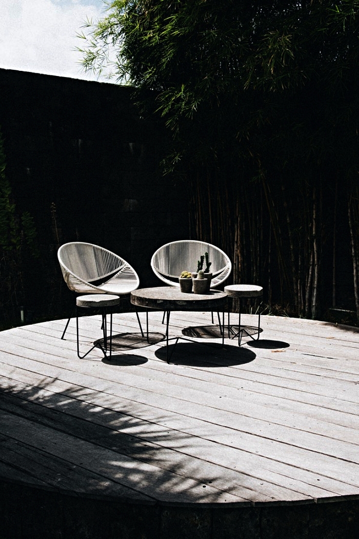 salon de jardin moderne de fauteuils acapulco assortis avec une petite table de jardin rond en béton au piétement métallique
