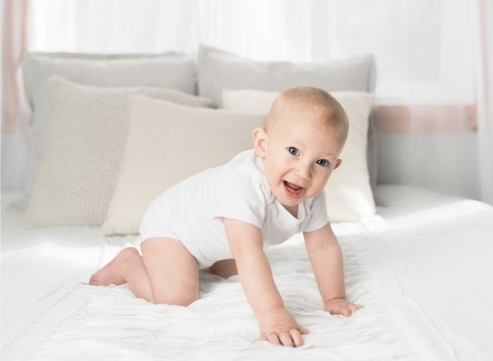 petit bébé sur un lit blanc, comment assurer un bon sommeil à votre bébé