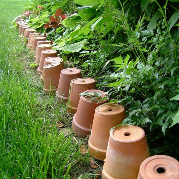 bordure en vieux pots d'argile, pelouse, parterre de plantes vertes, aménagement de jardin original