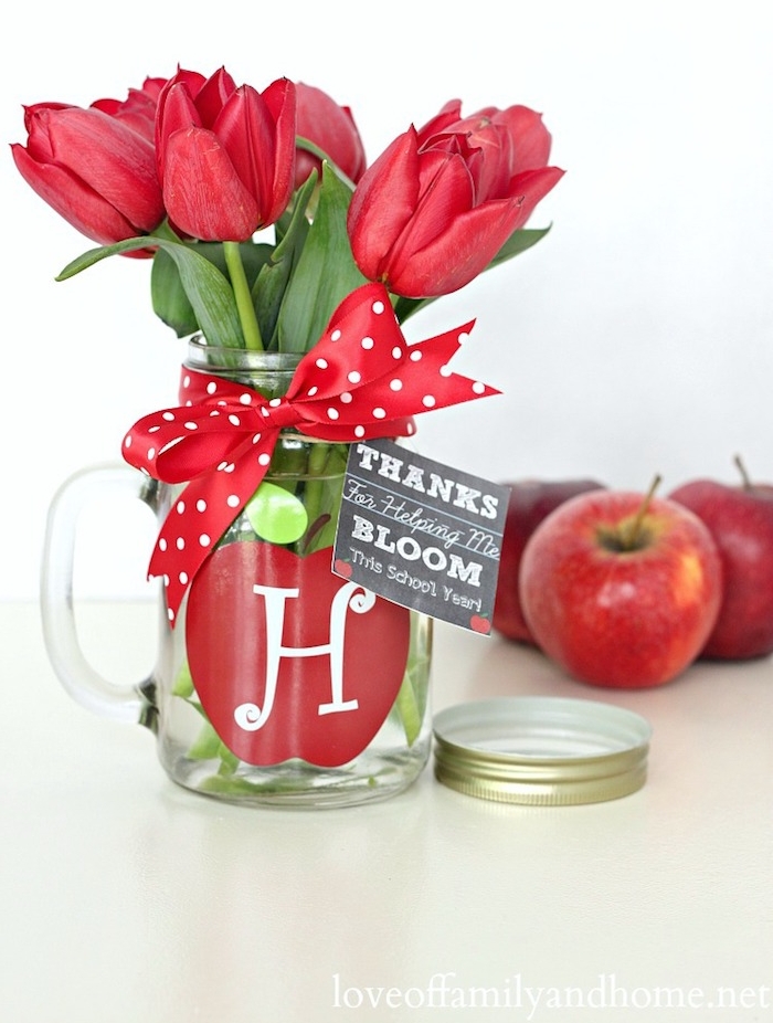 cadeau maîtresse école, idée de verre transformé vase de fleurs avec motif pomme rouge, symbole du savoir et de la sagesse et bouquet de tulipes