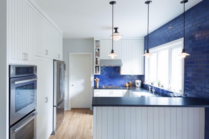 idée cuisine petit espace, décoration cuisine blanche avec carreaux bleu et plan de travail en noir, revêtement plancher cuisine en bois
