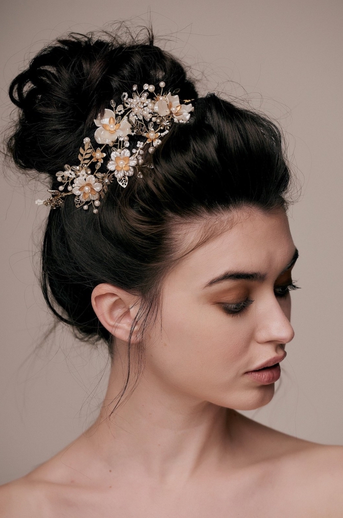 modèle de coiffure de mariage aux cheveux attachés en chignon bas flou avec branche fleurie, modèle de chignon cheveux long