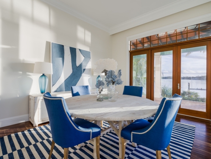 agencement salle à manger au plancher bois foncé avec meuble bois clair, modèle de chaise couleur bleu marine