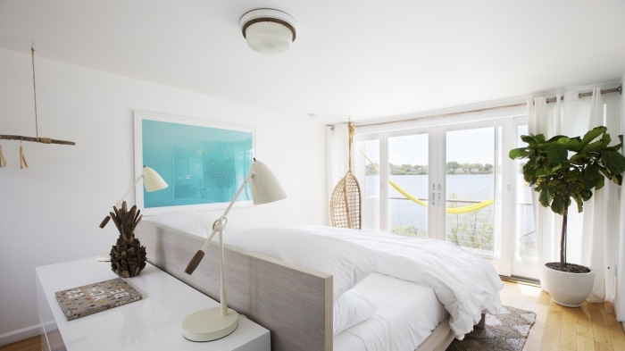 design intérieur style minimaliste, modèle de chambre à coucher blanche au parquet bois avec accessoires de decoration marine