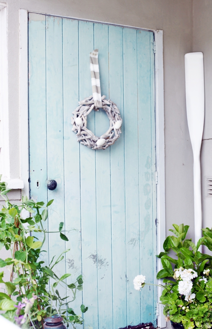 comment relooker une vielle porte d'entrée en bois, exemple porte bois récup avec peinture bleu pastel et couronne