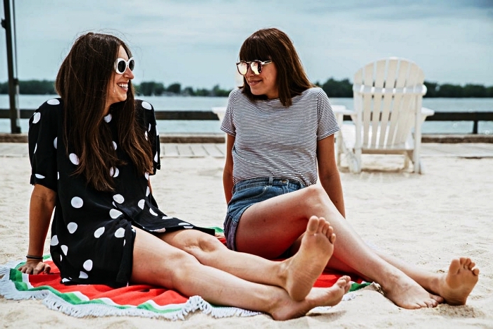 comment s'habiller à la plage, tunique de plage chic noire à pois blancs assortie avec des lunettes de soleil rétro à cadre blanc, t-shirt coton combiné avec un short denim et lunettes de soleil en verre miroir