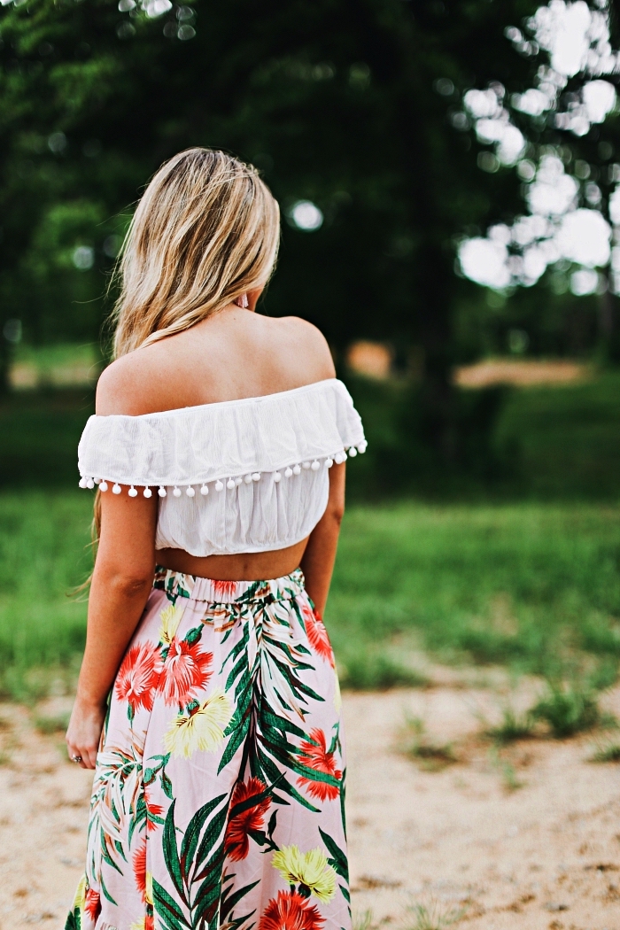 tenue d'été femme pour aller à la plage, jupe maxi imprimé tropical associé à un top bardot blanc bordé de pompons