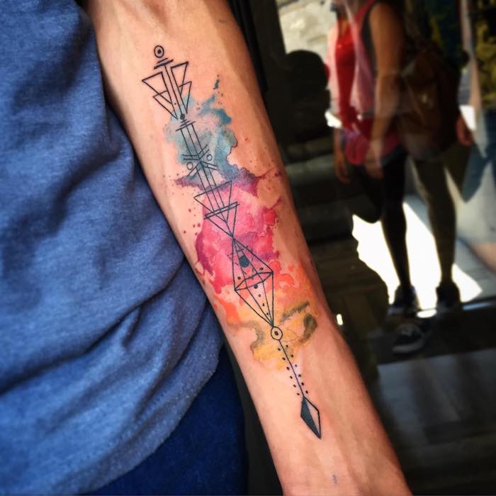 tatouages avec symboles originaux sur fond en aquarelle, nuages colorés abstraits