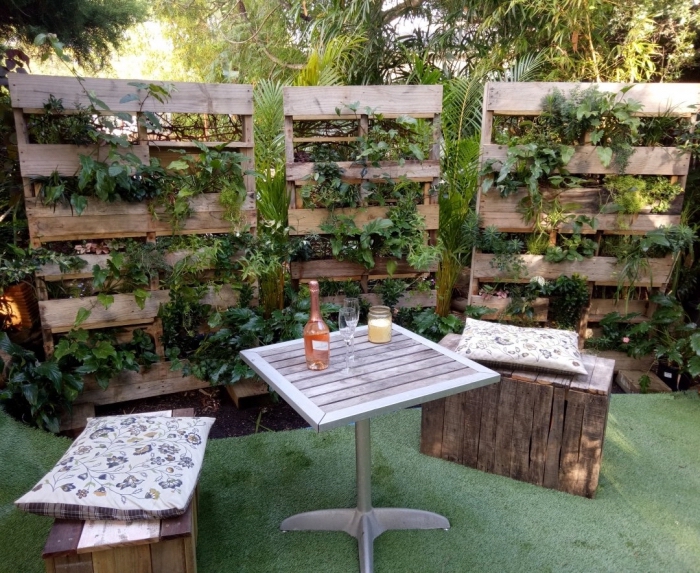 comment aménager un jardin avec tapis faux gazon et meubles en bois recyclé, exemple de mur végétal palette