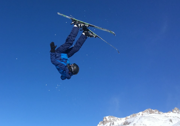 figure de skieurs en l'aire, skier en France, montagne enneigée et ciel bleu, trouver une destination de vacances en France