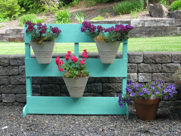 pots de fleurs fixés sur un rangement pour plantes en lattes de bois repeintes de couleur bleue