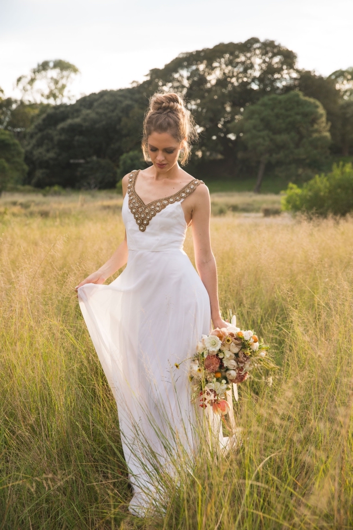 modèle de chignon mariage haut, exemple de robe de mariée longue avec décoration décolleté en or, coiffure cheveux attachés