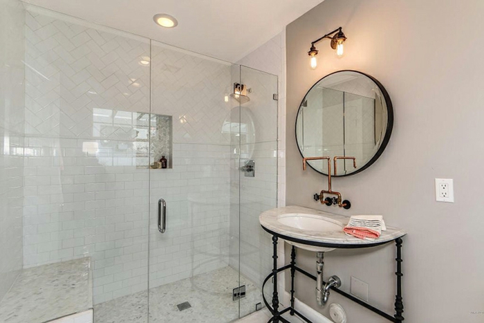 petite salle de bain en noir et blanc, miroir rond, vasque blanche, parois de douche en verre, carrelage douche metro
