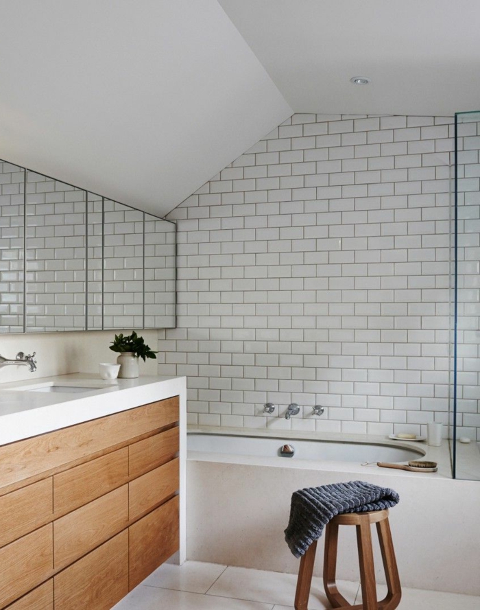 salle de bain scandinave, lavabo bois et blanc, baignoire encastrable, tabouret en bois, carrelage blanc