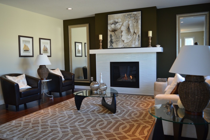 salon compacte et élégant avec cheminée blanche, tapis beige, fauteuils noirs en cuir, table basse
