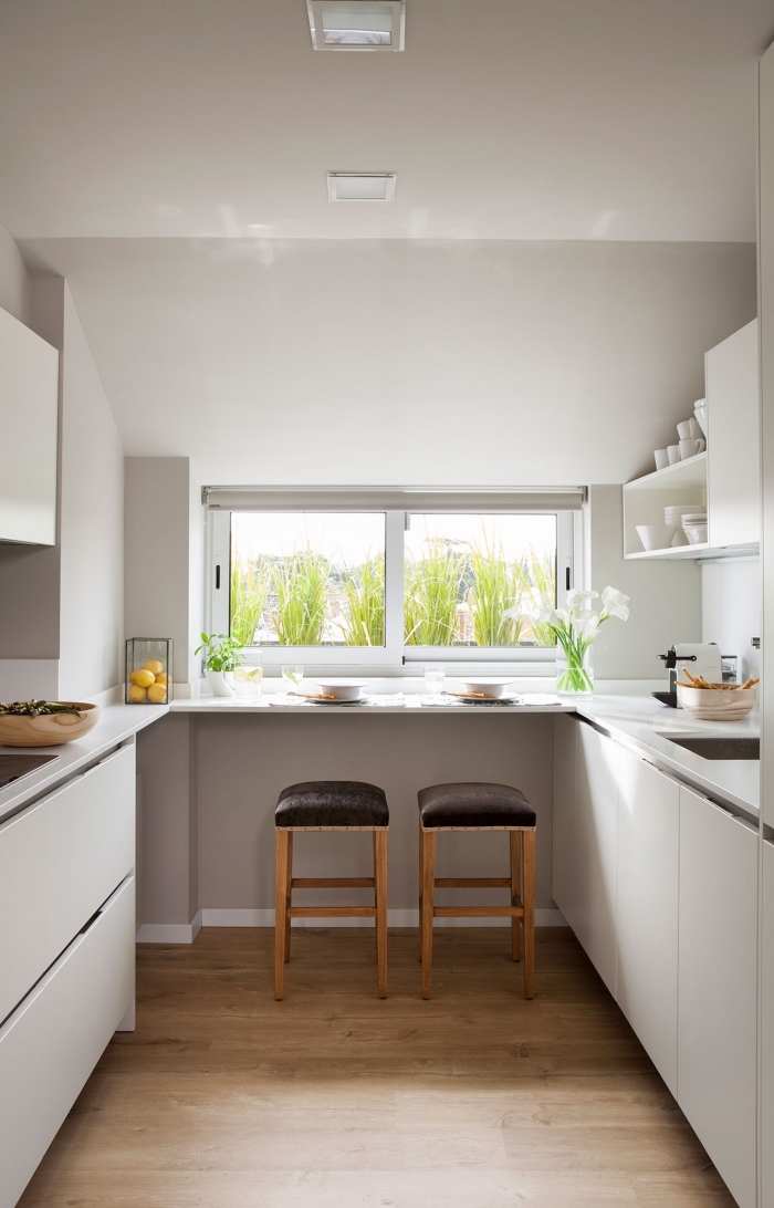 idée aménagement cuisine en forme U, exemple de cuisine petit espace en blanc, modèle cuisine avec petites fenêtres et parquet bois