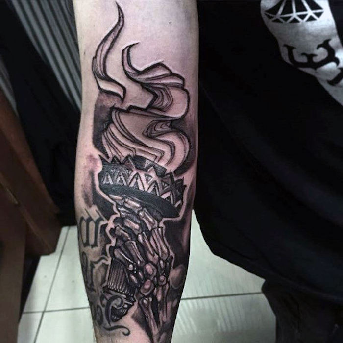 idée de dessin torche en flammes sur la peau tenue par la main d'une squelette, tatouage gothique homme