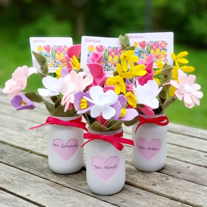 vase de fleurs en pot de verre recyclé repeint en blanc avec coeur rose et nom maitresse écrit dessus et des fleurs en feutrine, étiquette cadeau à motif fleurs