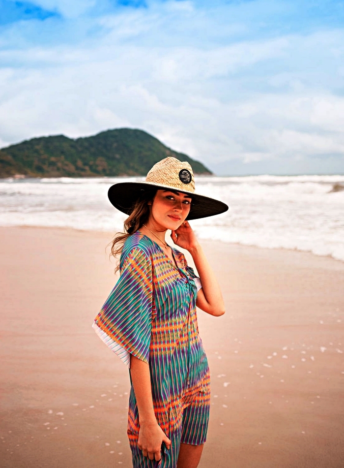look de plage en caftan de plage multicolore à manches évasées et chapeau de paille à large rebord