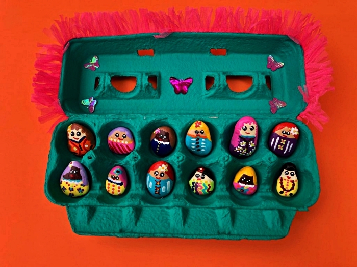 personnages amusants en galets décoratifs peints à la main dans une boîte d'oeufs récup verte, que faire pendant les vacances pour occuper les enfants