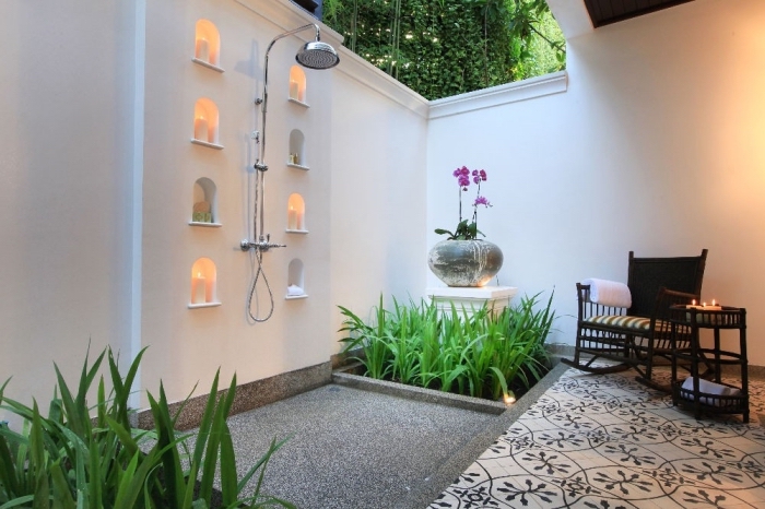 modèle de salle de bain zen dans le jardin avec douche pluie en inox et meubles de jardin en bois tressé noir