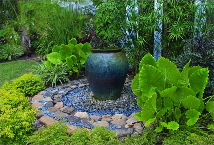 aménagement paysager, grand pot en argile comme point focal, plantes à grandes feuilles, gravier décoratif, gazon tondu 