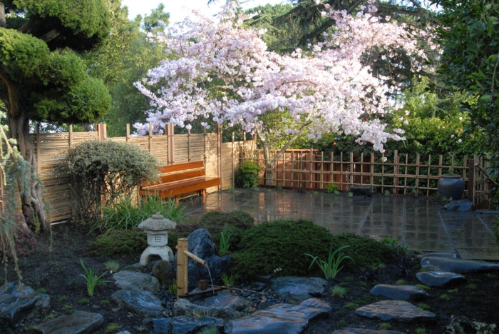 jardin zen, banquette, pierres décoratives, lanterne japonaise, clôture bambou, arbre fleuri