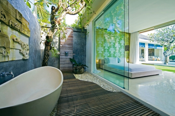 aménagement de salle de bain dans la cour arrière avec murs à peinture à effet béton et receveur de douche rectangulaire en bois