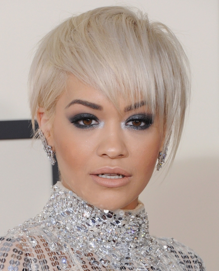 idée coupe de cheveux courts tendance femme 2019, Rita Ora aux cheveux en coupe garçon avec frange longue en blond polaire