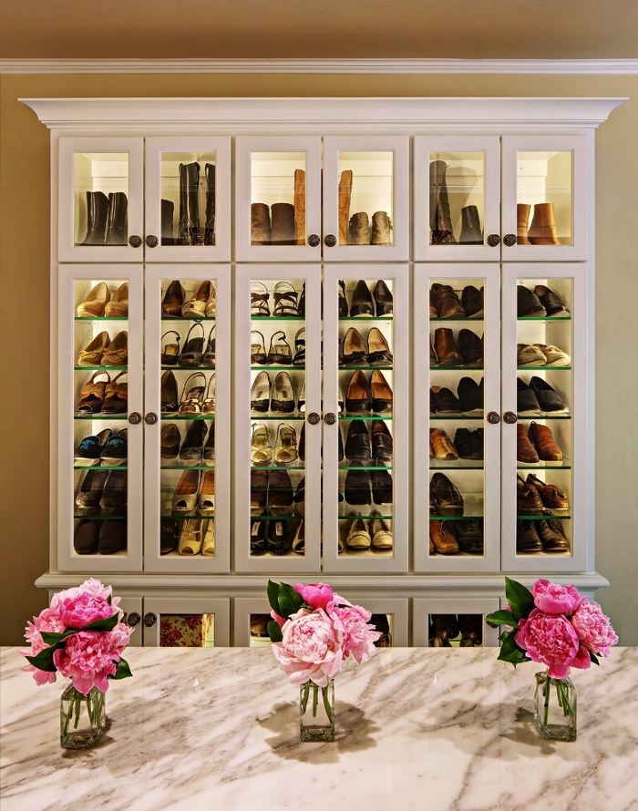 meuble de rangement chaussure dans une pièce dressing avec îlot central en marbre, grande armoire vitrine pour ranger ses chaussures de façon stylée
