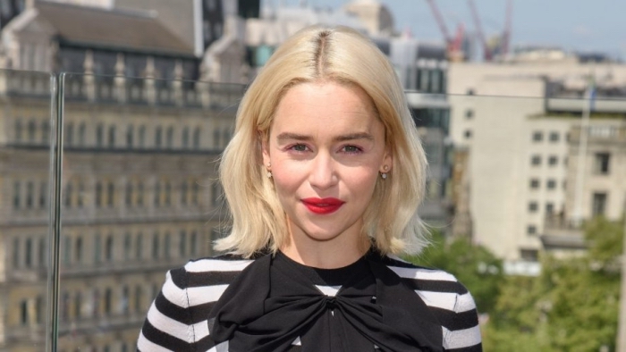 Emilia Clarke aux cheveux longs en coupe carré mi longs avec pointes légèrement ondulés et racines foncées