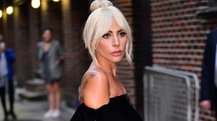 Lady Gaga aux cheveux en chignon haut, couleur de cheveux blond blanc de Lady Gaga, coupe cheveux femme avec frange rideaux