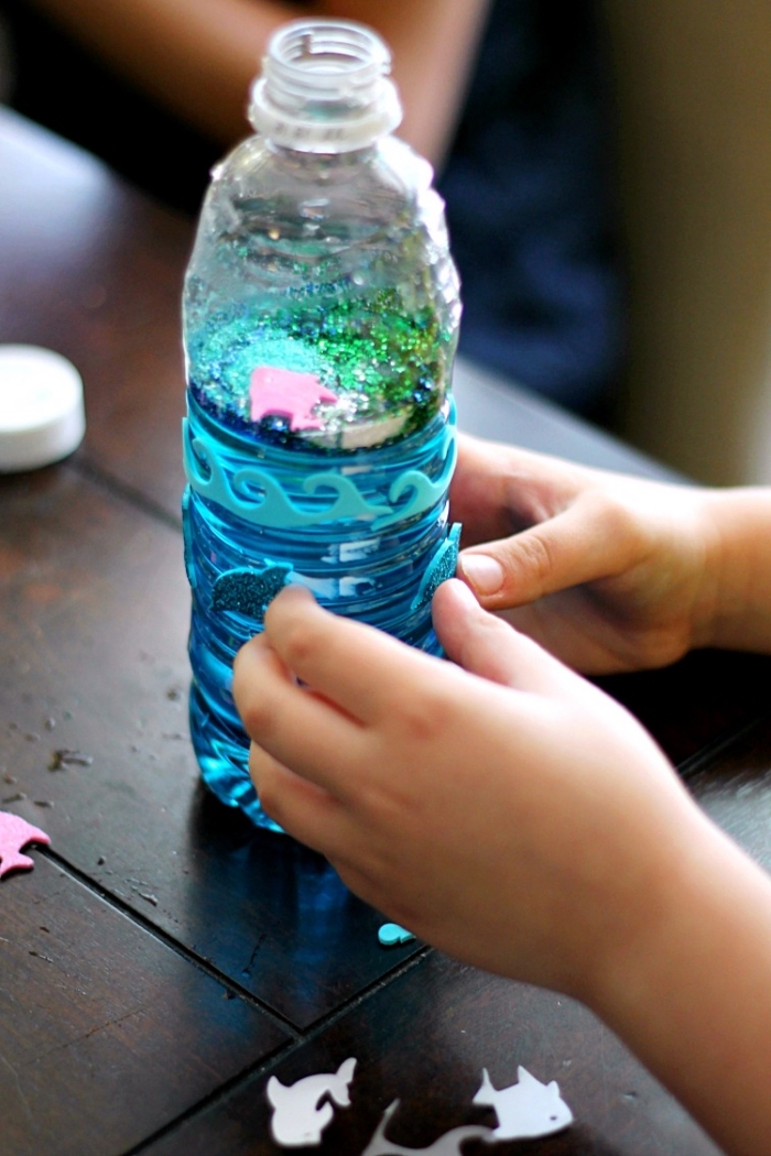 fabriquer des bouteilles sensorielles, modèle de bouteille Montessori sur thème fond de mer avec eau colorée et figurine animaux