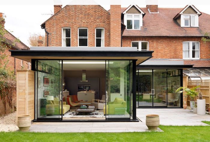 cuisine ouverte sur salon pour aménager un agrandissement maison contemporain sur terrasse en bois à coté d une maison de birques anglaise