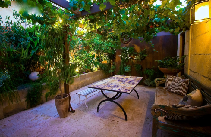 amenagement petit jardin, grande banquette en bois, pot de fleurs avec arbres plantés, petit espace extérieur cosy