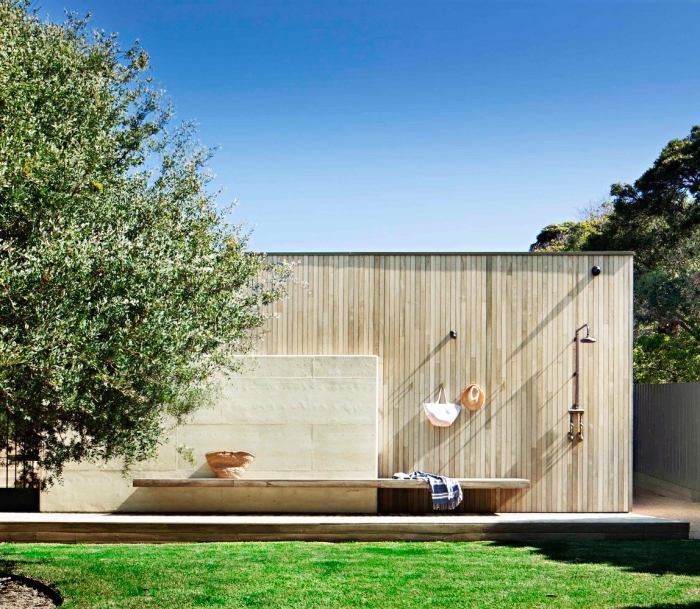 amenagement jardin paysager, modèle de salle d'eau extérieure avec douche en métal et crochets fixés sur murs pour serviettes